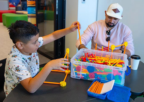 A boy and his dad building with K-nex