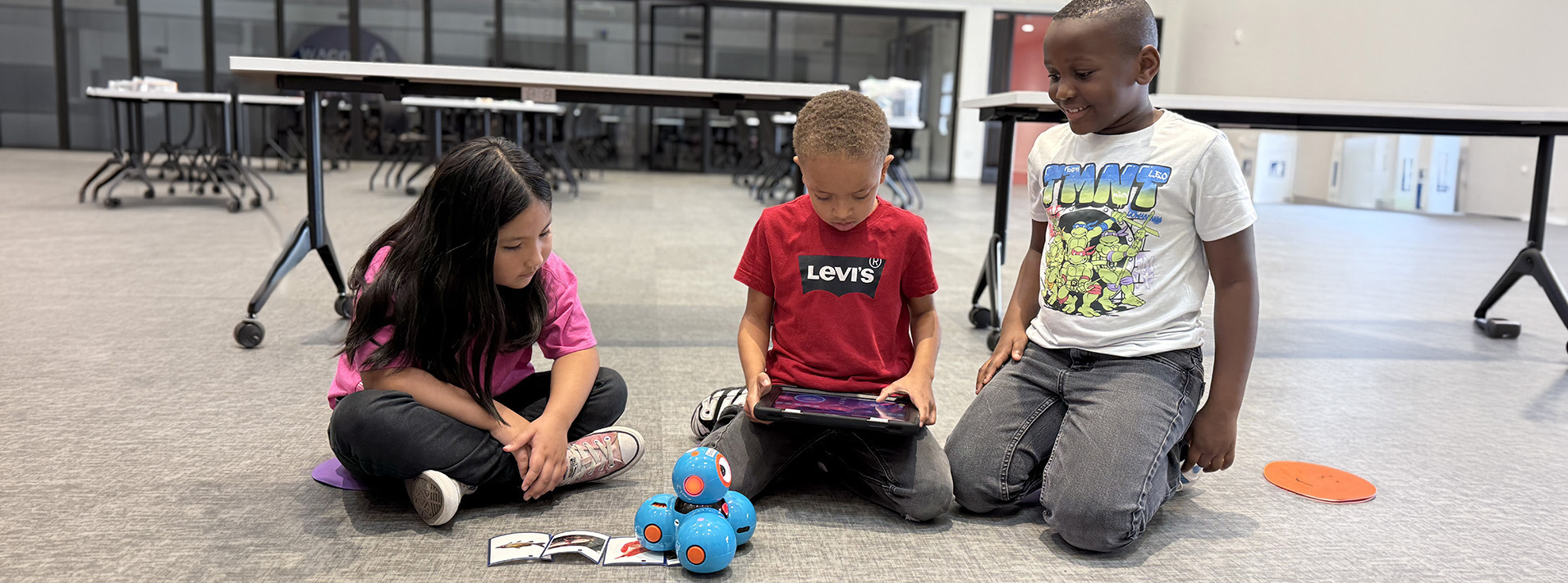 Three students controlling a small robot.